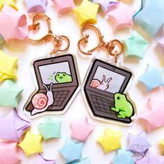 two key chains that have pictures of laptops on them with stars in the background