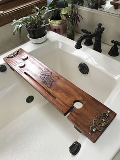 a wooden board sitting on top of a white sink next to a faucet