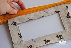 someone is stitching together fabric to make a photo frame