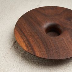 a wooden object sitting on top of a white surface