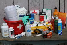 an assortment of medical supplies sitting on top of a wooden table in front of a fence