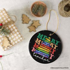 a merry teacher ornament surrounded by christmas decorations