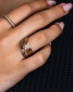 a woman's hand with two rings on her fingers and one ring in the middle