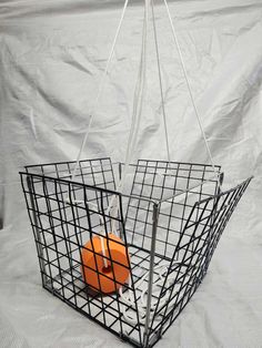 a metal basket with an orange object hanging from it