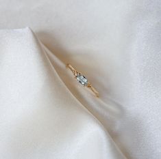 a diamond ring sitting on top of a white cloth