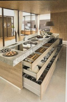 an open kitchen with lots of drawers and counter space in the center is filled with food