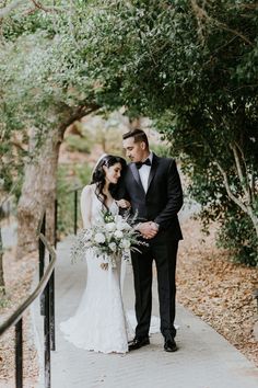 a bride and groom standing on a walkway