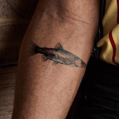 a man with a fish tattoo on his arm