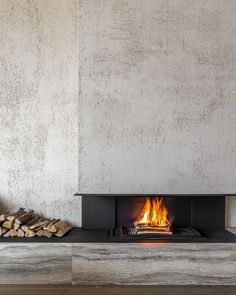 a fireplace with logs in front of it and a fire place next to the wall