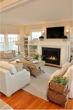 a living room filled with furniture and a flat screen tv mounted on the wall above a fire place