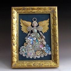 an ornate gold frame holds a decorative angel ornament in the shape of a christmas tree