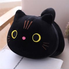 a black cat pillow sitting on top of a table