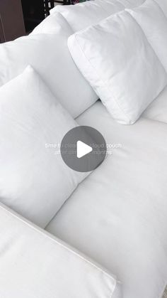 a bed with white sheets and pillows on it