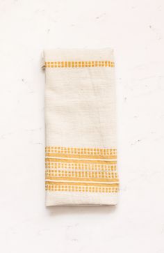 a yellow and white towel sitting on top of a table