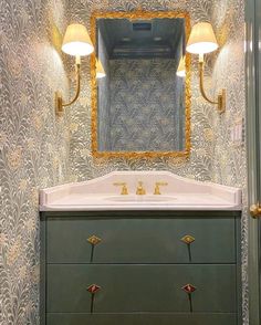 a bathroom with a sink, mirror and lights on the wall above it's vanity