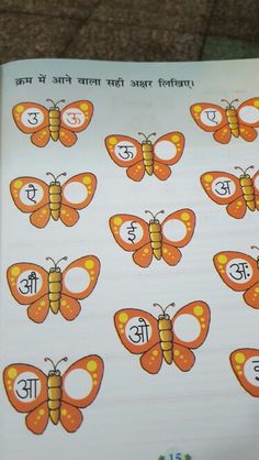 an open book with pictures of butterflies and letters in english on the pages, which are written in two different languages