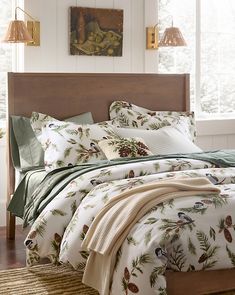 a bed in a bedroom with pine cones on the comforter and pillows, along with two lamps