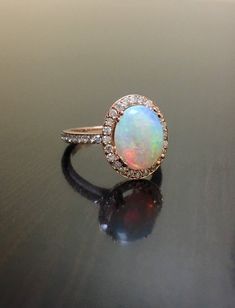 an opal and diamond ring on a table