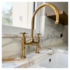 a gold faucet on a marble counter top