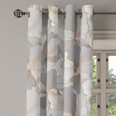 an open window with white curtains in front of it and a flower pattern on the curtain