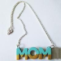 a necklace with the word mom hanging from it's center, on a white surface