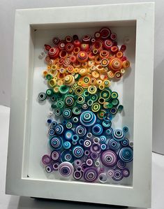 an art work made out of paper with circles in the shape of a rainbow on it