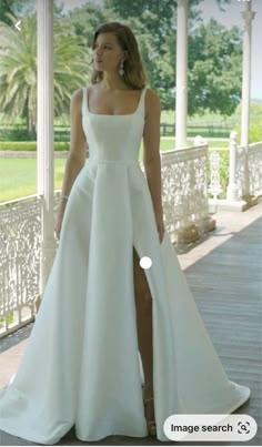 a woman in a white dress standing on a porch