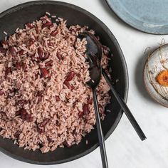 a bowl filled with rice and beans next to other dishes