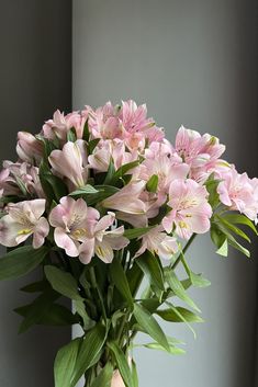 a vase filled with pink flowers on top of a table