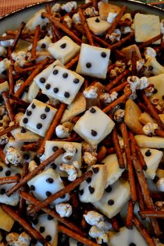 a platter filled with lots of cheese and pretzel sticks covered in chocolate chips