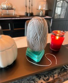 a ball of yarn sitting on top of a table next to a tea light holder