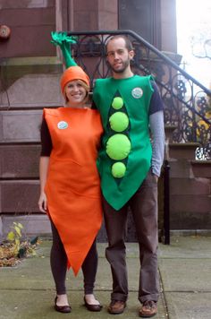 a man and woman are dressed up as peas and carrots on the sidewalk in front of a building