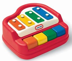 an electronic toy with multicolored keys on the front and sides, sitting in a red case