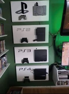 there are several video game consoles on display in this room with green walls and white shelves