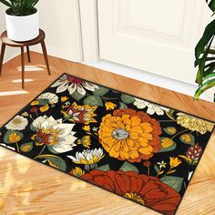 an area rug with flowers on it in front of a door and potted plant