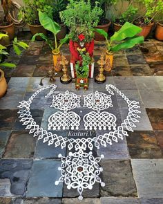 an intricately designed design on the ground in front of potted plants and other decorations