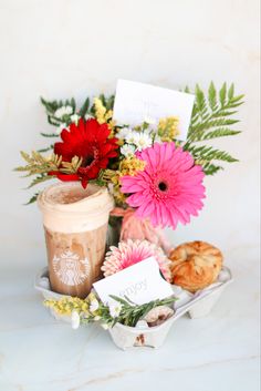 a cup of coffee and some flowers on a table