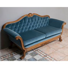 a blue couch sitting on top of a tiled floor