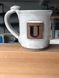 a coffee mug with the letter u painted on it