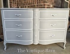 an old dresser is painted white and has drawers