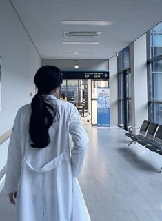 a woman walking down a hallway next to an airport