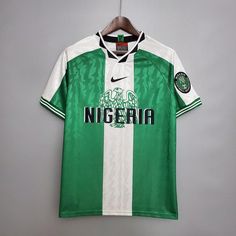 a green and white soccer jersey hanging on a hanger