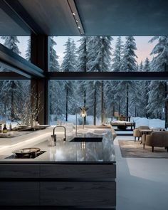 a large kitchen with an island counter and chairs in front of a window that looks out onto the woods