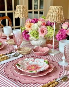 a table set with pink and white dishes