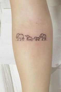 an elephant family tattoo on the left thigh, with three elephants in line across it