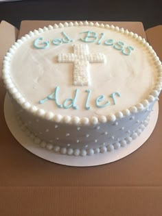 a white cake with blue frosting and a cross on top that says god, bless'aller