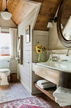 a bathroom with a sink, toilet and rug in it's centerpieces