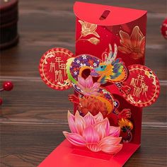 a red card with an image of a dragon and flower on it, sitting on a wooden table