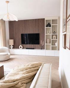 a living room filled with furniture and a flat screen tv on top of a wall