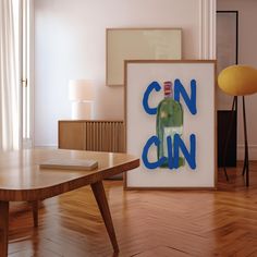 an art work is displayed on the floor in front of a coffee table and lamp